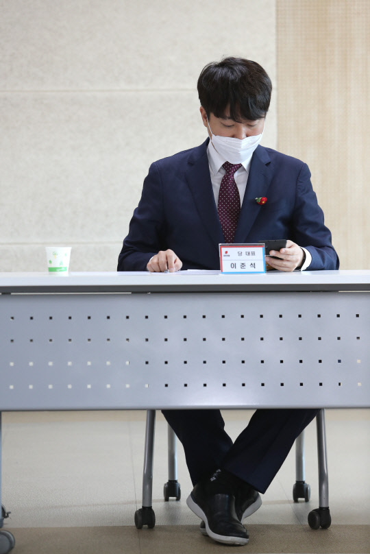 국민의힘 이준석 대표가 21일 오전 전남 순천시 순천팔마종합운동장 올림픽기념국민생활관에서 열린 전남도당 당협위원장 회의에서 휴대전화를 보고 있다. 연합뉴스